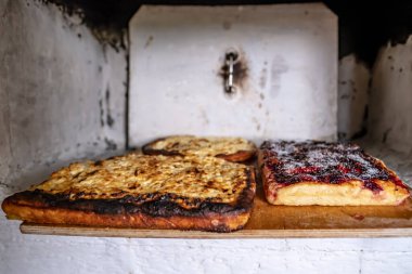 Rus fırınında pişmiş iştah açıcı turtalar köy evindeki ahşap bir kesme tahtasının üzerinde yatıyor. Geleneksel mutfak.