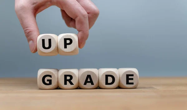 Kości zbudowane słowo "Upgrade", podczas gdy ręka podnosi litery " — Zdjęcie stockowe