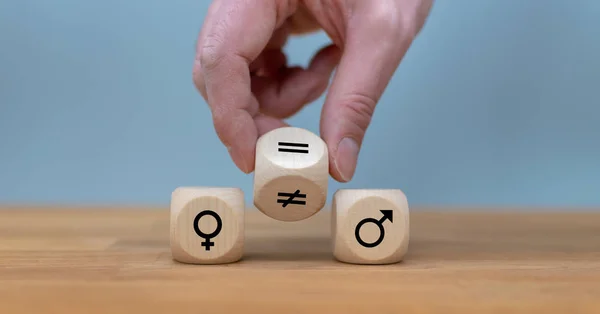 Símbolo para la igualdad de género. La mano gira un dado y cambia una uneq — Foto de Stock
