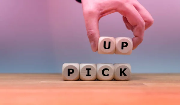Symbol to pick up waste. Dice form the word "PICK UP" while a ha — Stock Photo, Image