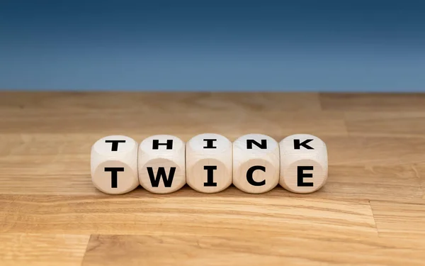 Dice утворюють слова "THINK TWICE ". — стокове фото