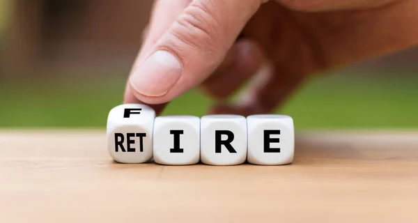 Retire or get fired. Hand turns a dice and changes the word "fir — Stock Photo, Image