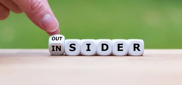 Hand turns a dice and changes the word "OUTSIDER" to "INSIDER" ( — Stock Photo, Image