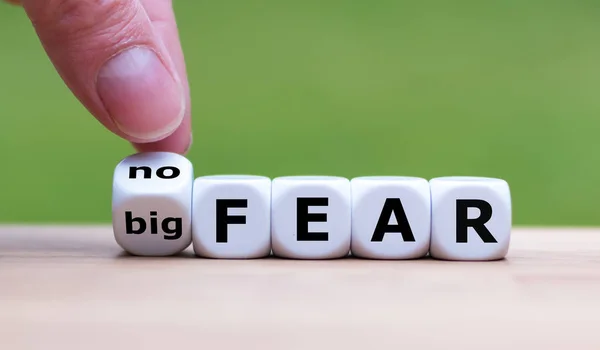 Hand turns a dice and changes the expression "big fear" to "no f — Stock Photo, Image