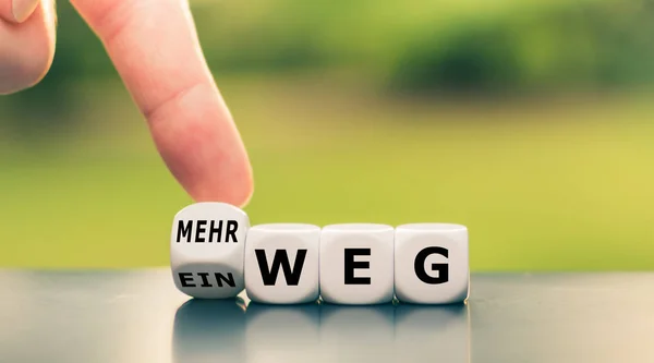 Hand draait een dobbelsteen en verandert het Duitse woord "Einweg" ("single — Stockfoto