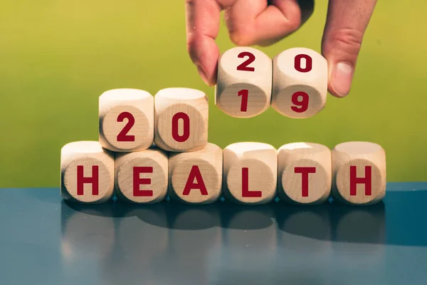 Рука перетворює кубики і змінює вираз " 2019 Health" на "20 — стокове фото