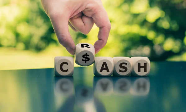 Bargeld oder Crash? Hand dreht einen Würfel und ändert das Wort "Crash" in — Stockfoto