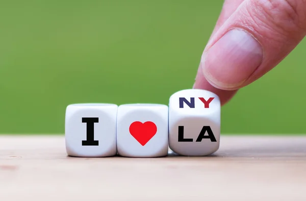 Hand turns a dice and changes the expression "I love LA" to "I l — Stock Photo, Image