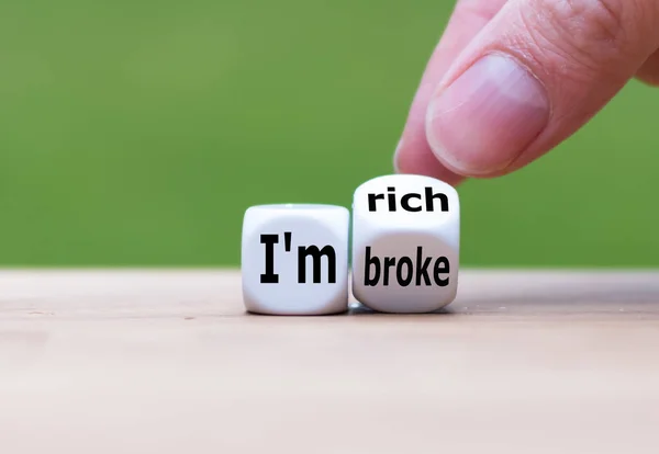 Hand turns a dice and changes the expression "I'm broke" to "I'm — Stock Photo, Image