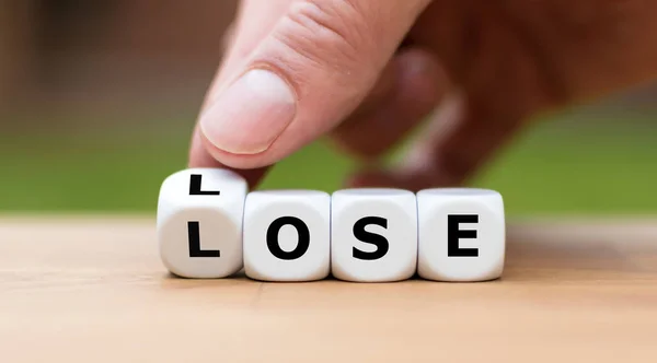 Verlies de situatie. Hand draait dobbelstenen en verandert het woord "verliezen" — Stockfoto