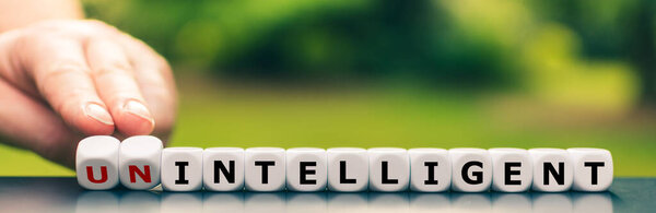 Hand turns dice and changes the expression "unintelligent" to "intelligent".