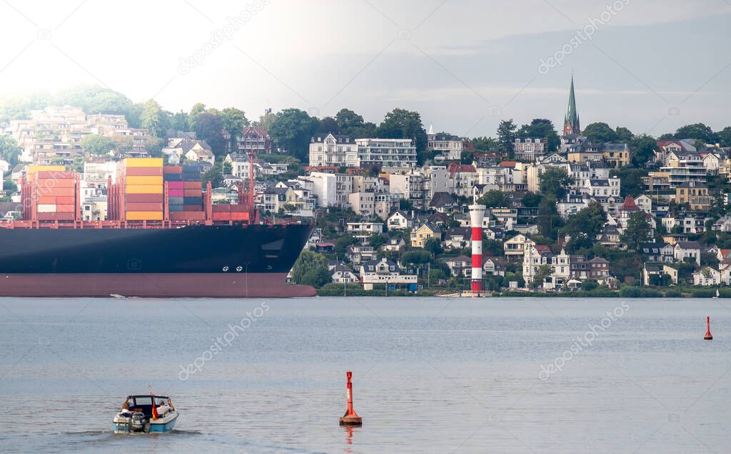 Container ship on the river Elbe in front of the district Blankenese in Hamburg, Germany.
