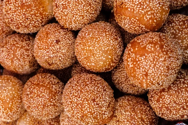 fried sweet asian chinese or thai balls in sesame at the market street food festival. close up