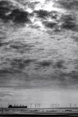 Huysuz bir tek renkli görüntüyü o Burbo daireler Liverpool Bay üzerinde Burbo Bankası Offshore Rüzgar Çiftliği geçerken sonra Liverpool çıkış yapan bir gemi. Dramatik bulutlar ve gökyüzü yolculuğuna ilk ayağı için eşlik.