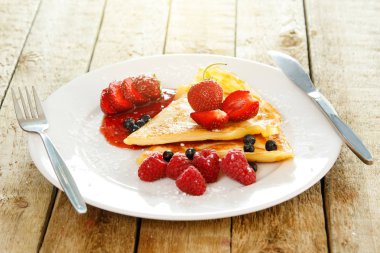 Taze meyveleri ve ahşap masa üzerine pudra şekeri ile Pancakes