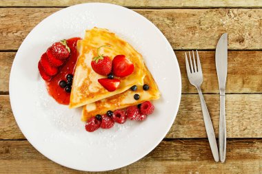 Taze meyveleri ve ahşap masa üzerine pudra şekeri ile Pancakes