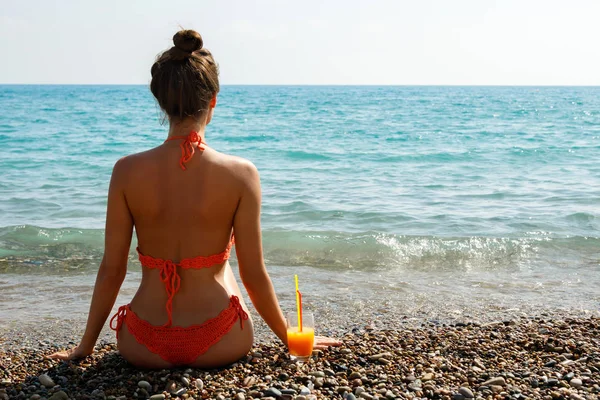 Bir kadeh kokteyl ile sahilde güzel genç kadın