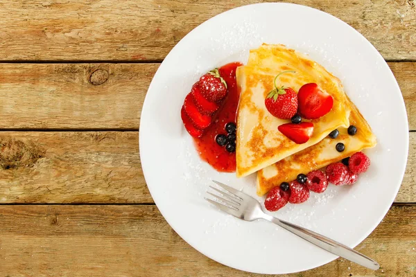 Taze meyveleri ve ahşap masa üzerine pudra şekeri ile Pancakes