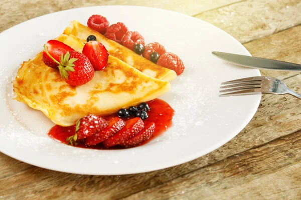 Taze meyveleri ve ahşap masa üzerine pudra şekeri ile Pancakes
