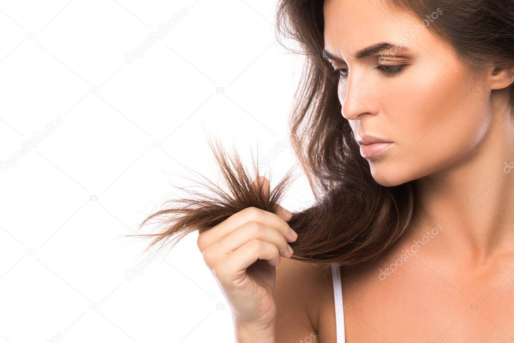 Young woman unhappy with split ends of her hair