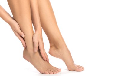 Kadın yaralı ayak beyaz zemin üzerine dokunuyor