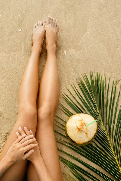 女性の足や砂浜のビーチでカクテル ココナッツ — ストック写真