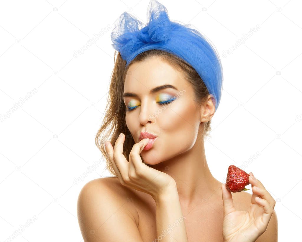 Beautiful woman with colorful makeup and strawberry on white background
