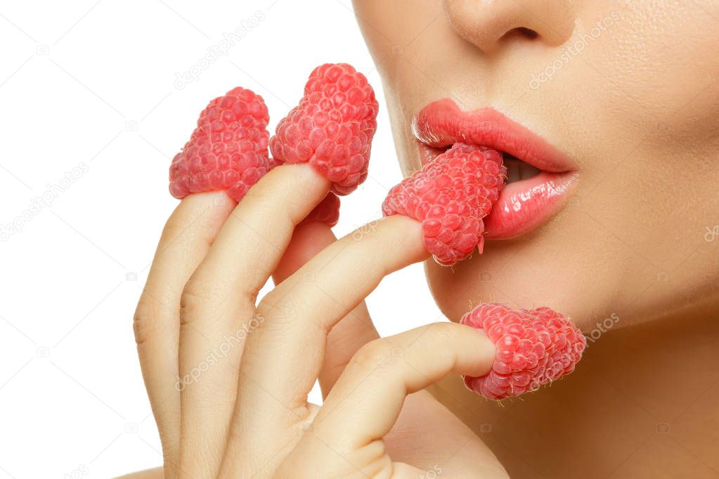 Close up view of female lips and raspberries