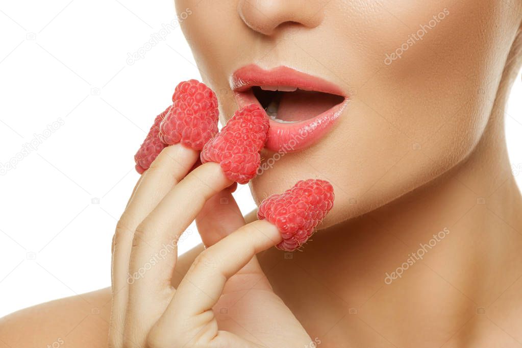 Close up view of female lips and raspberries