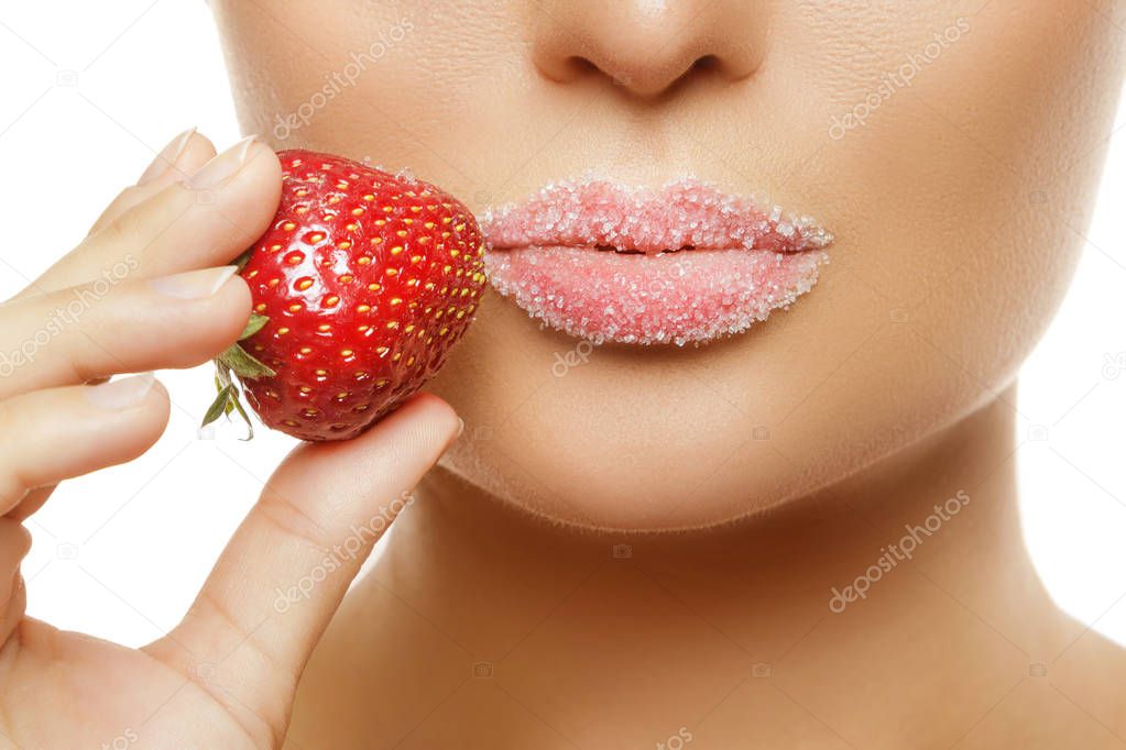 Close up view of female lips in sugar and strawberry