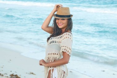 Sahilde poz hasır şapkalı kadın