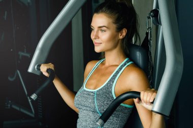 Spor salonunda basın makine kullanan genç sportif kadın