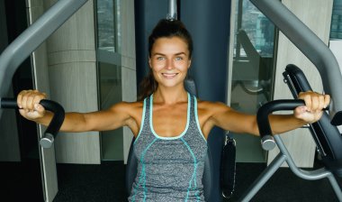 Spor salonunda basın makine kullanan genç sportif kadın