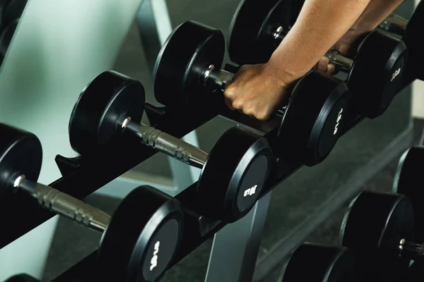 Row of dumbbells and female hands