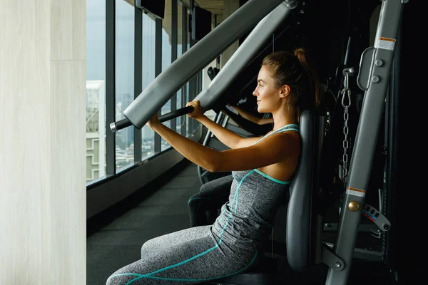 年轻运动的妇女使用压机在健身房 — 图库照片