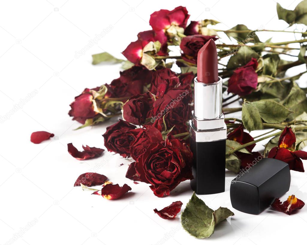 Close up view of lipstick and dried rose flowers