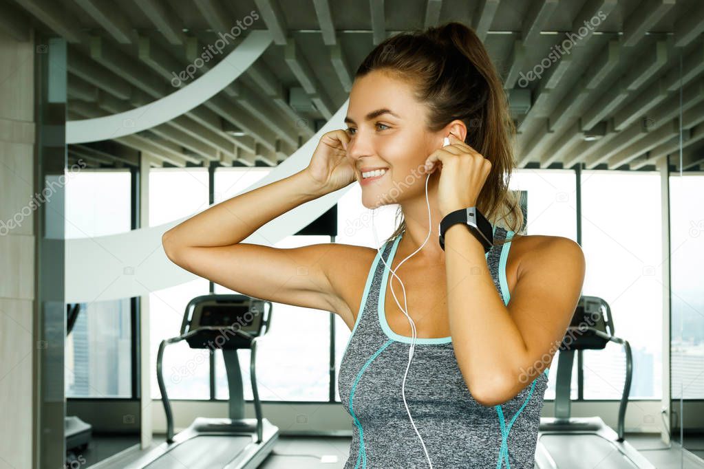 Sporty woman listening music during workout in gym