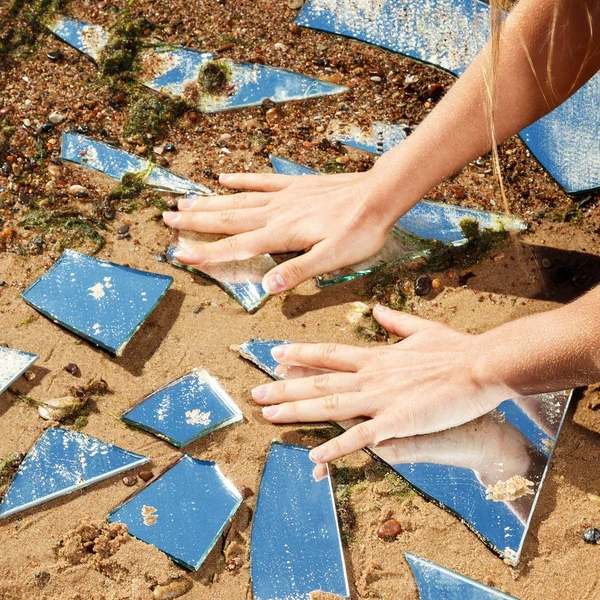 Female hands and lot of broken mirror shards