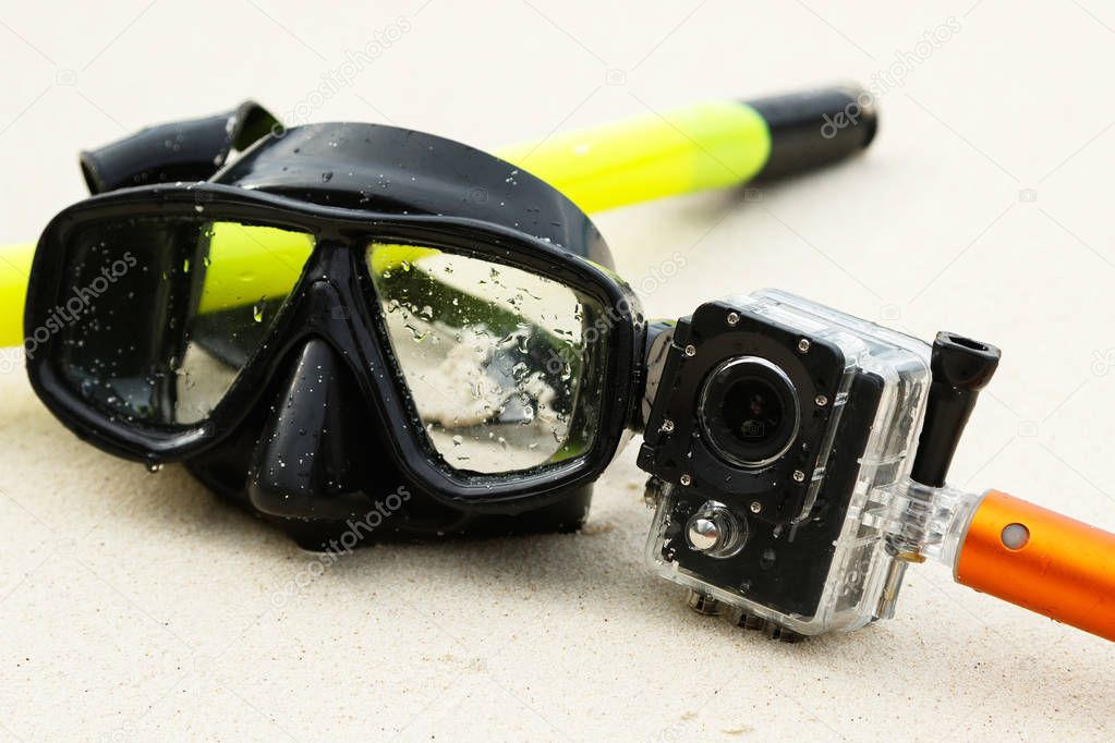 Mask for snorkeling and action-cam on the beach
