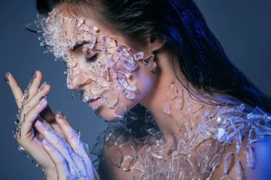 Kadın yüzü çok küçük cam parçaları ile kaplı. Silikon jel yapılan gerçekçi görsel efektler.