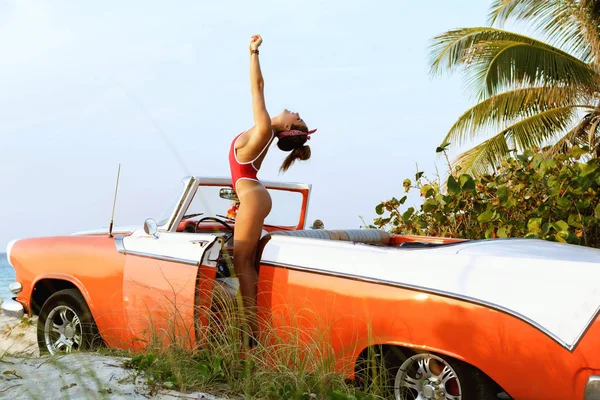 Σέξι Γυναίκα Κόκκινο Μαγιό Και Ρετρό Καμπριολέ Αυτοκίνητο Στην Παραλία — Φωτογραφία Αρχείου