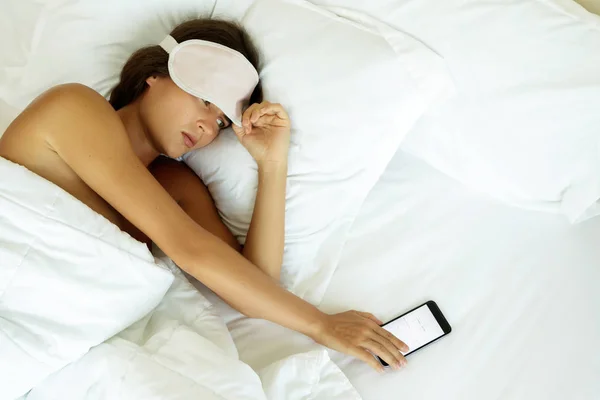 昏昏欲睡的女人看着智能手机 不想醒来 — 图库照片