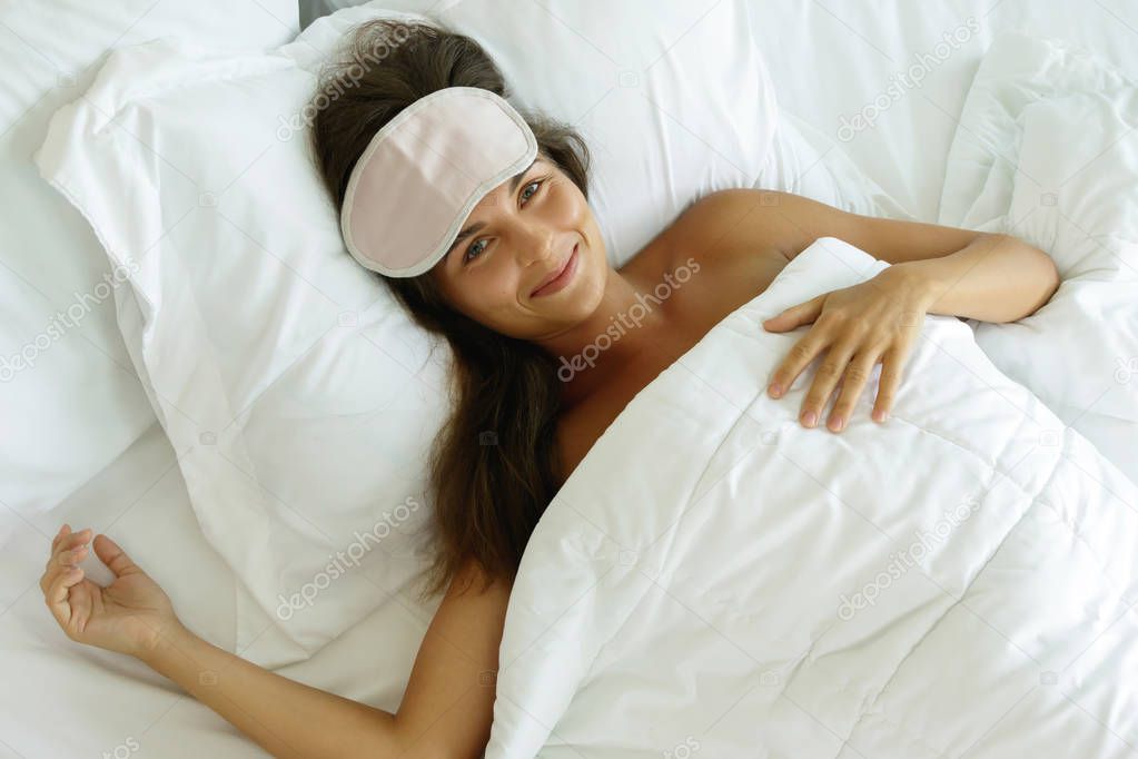 Happy woman waking up after good sleeping in bedroom