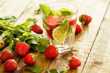 Çilek, limon ve nane ahşap masa üzerinde serinletici içecek