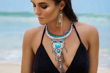Beautiful sexy young woman on beach wearing silver jewelry clipart