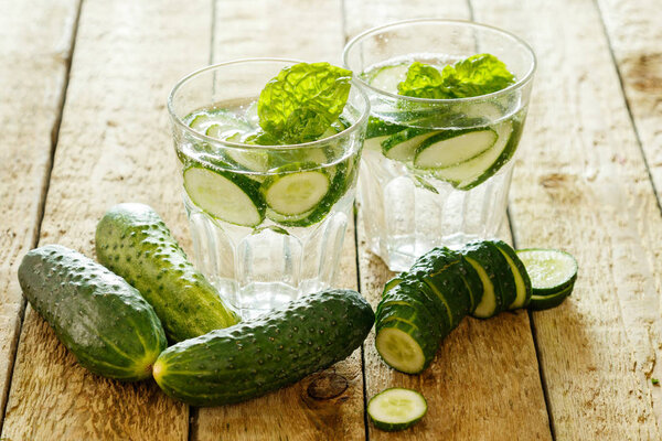 Detox water with cucumbers on wooden table