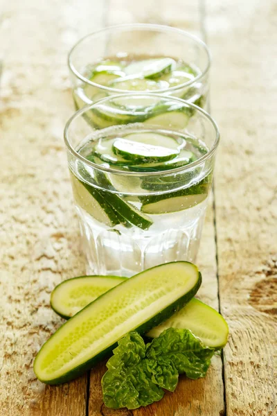 Detox water with cucumbers on wooden table