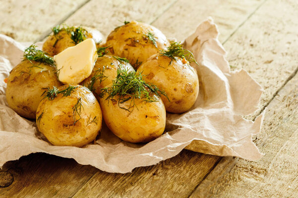 baked potatoes with dill on wooden table