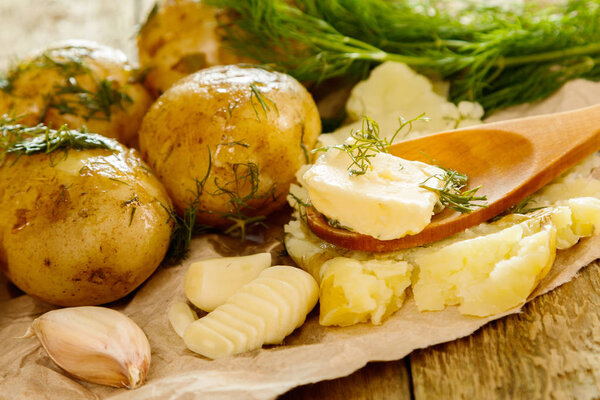 Baked potatoes with dill and garlic on wooden table