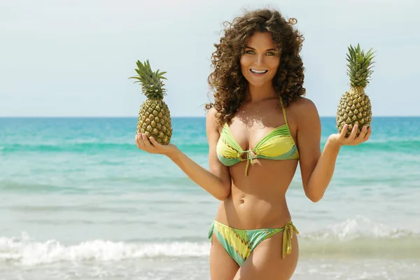 Piękne Kobiety Kręconymi Włosami Trzyma Ananasy Plaży — Zdjęcie stockowe